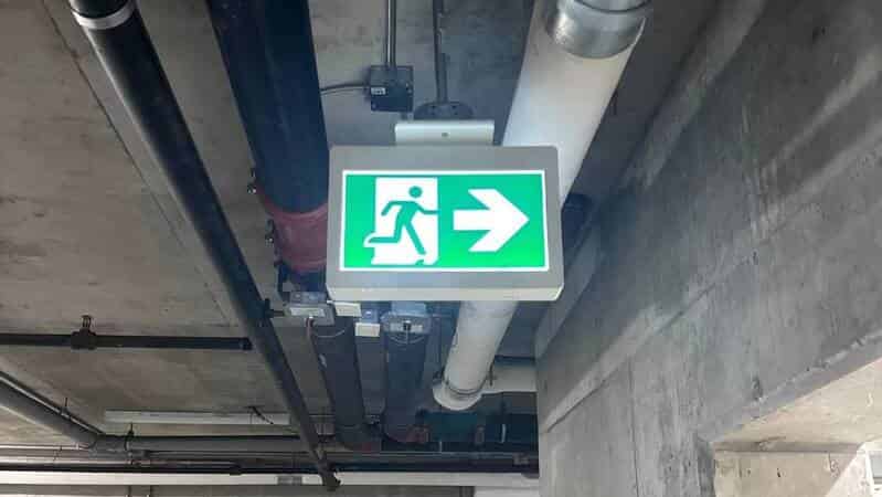 Illuminated emergency exit sign in parking structure