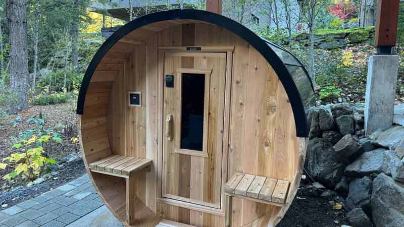 Cedar barrel sauna with control panel in backyard